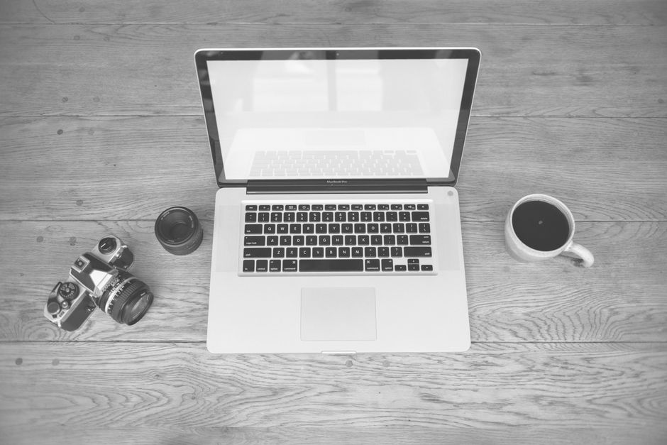 Apple MacBook Pro 35,97cm (14,2") űrfekete CTO 1 Monochrome image of a laptop, camera, lens, and coffee cup on a wooden desk
