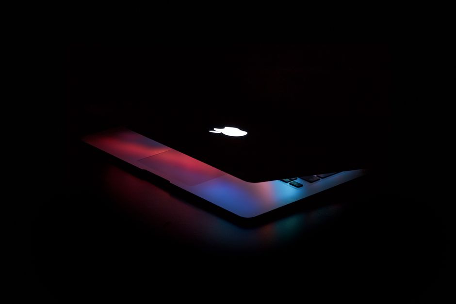 Apple MacBook Pro 41,05cm (16") ezüst CTO 1 Captivating close-up of a partially open laptop with colorful lighting against a dark background.