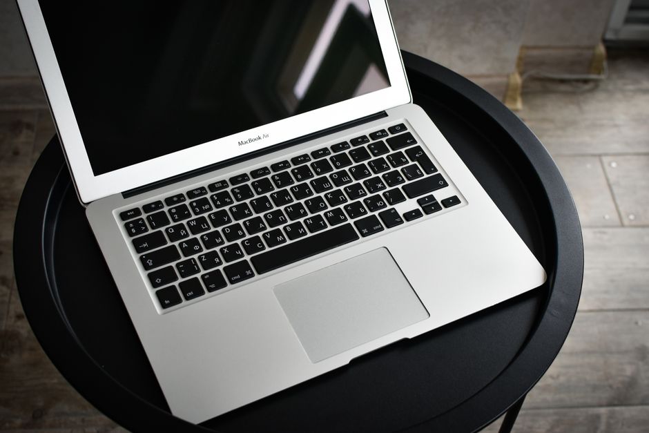 Apple MacBook Pro 35,97cm (14,2") űrfekete 1 A stylish laptop sits elegantly on a black round table in an indoor setting, ideal for tech and workspace themes.