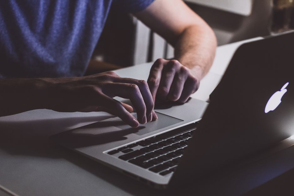 Apple MacBook Pro 35,97cm (14,2") űrfekete CTO 1 Close-up of hands typing on a laptop in a dark office setting. Perfect for business and technology themes.