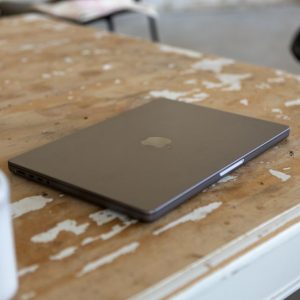 A sleek laptop rests on a rustic wooden table, embodying a blend of technology and minimalism.